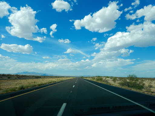empty road with blue skies and white clouds